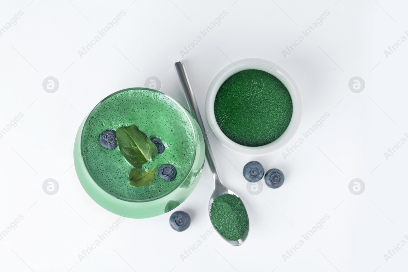 Photo of Spirulina smoothie, powder and fresh blueberries on white background, top view