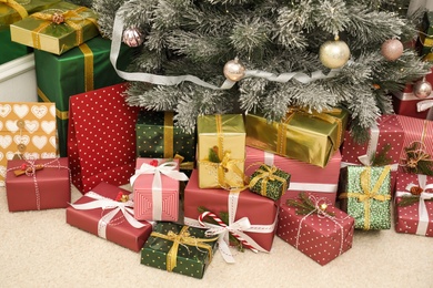 Many different gifts under Christmas tree indoors