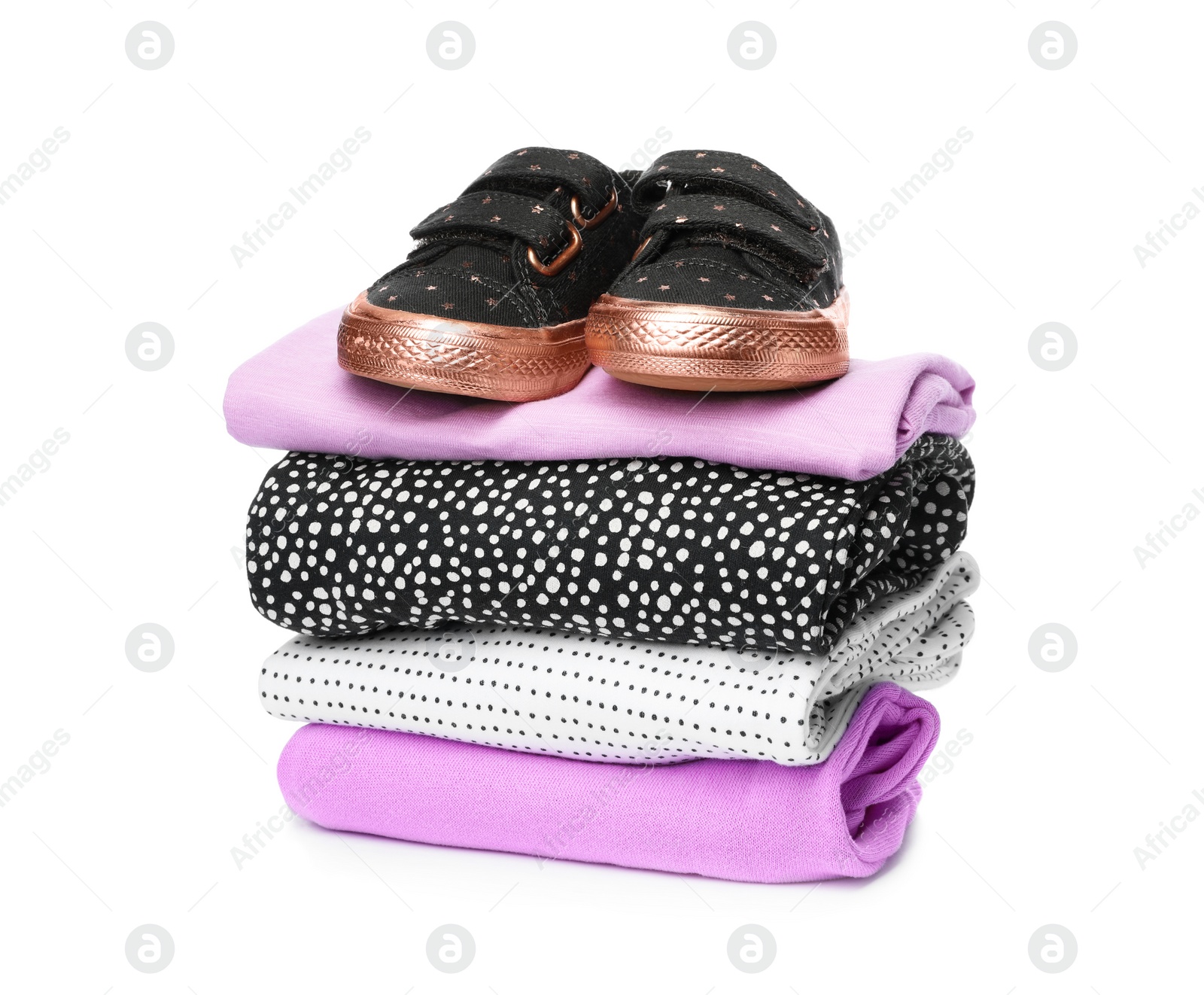 Photo of Children's shoes and stack of clothes on white background