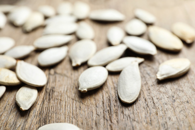 Photo of Raw pumpkin seeds on wooden background, closeup. Vegetable planting