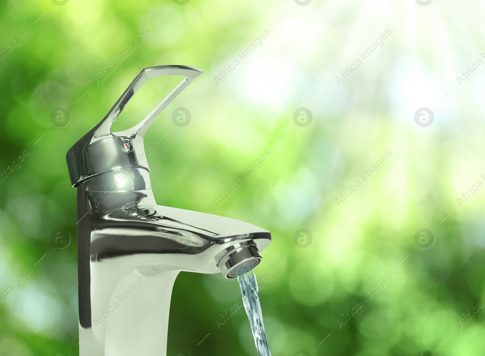 Image of Water flowing from tap outdoors on sunny day, bokeh effect