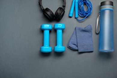 Sports equipment, socks and headphones on grey background, flat lay. Space for text