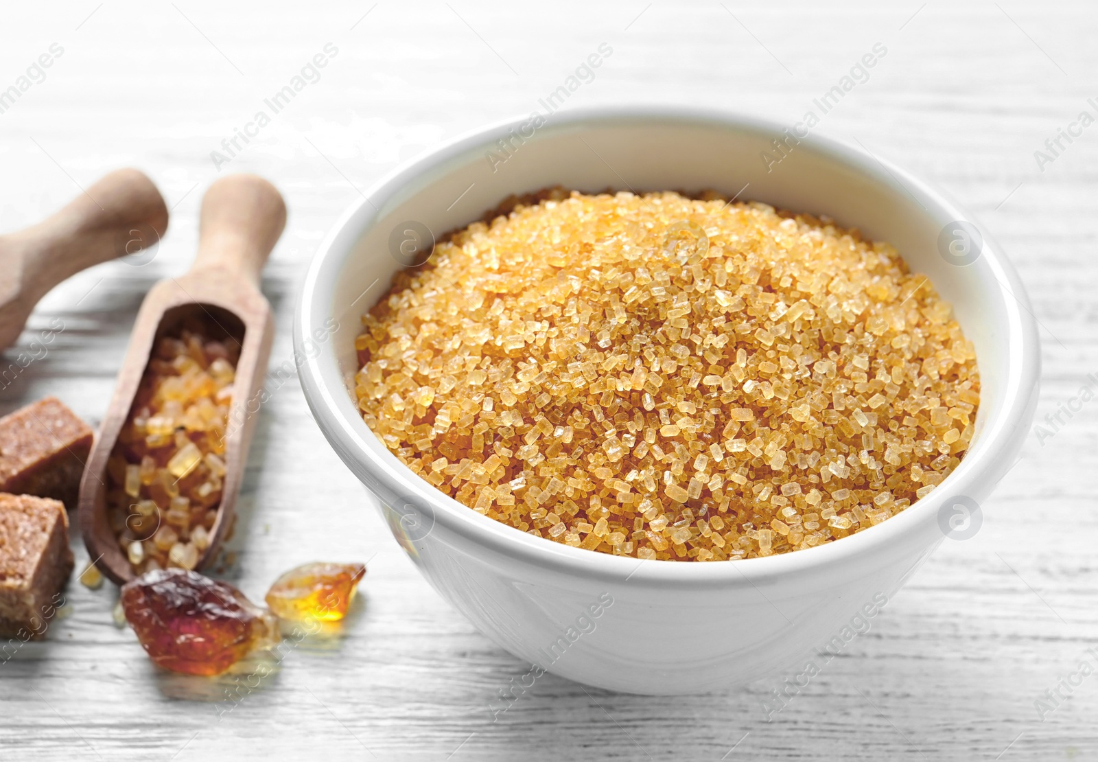 Photo of Bowl with brown sugar on wooden background