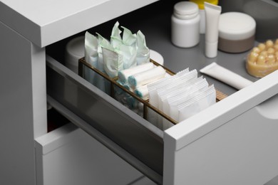 Storage of different feminine and personal care products in drawer, closeup