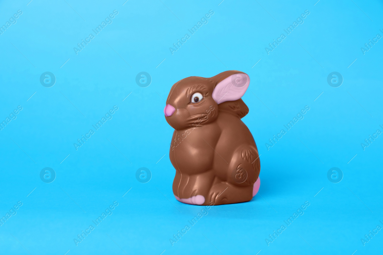 Photo of Chocolate bunny on light blue background. Easter celebration