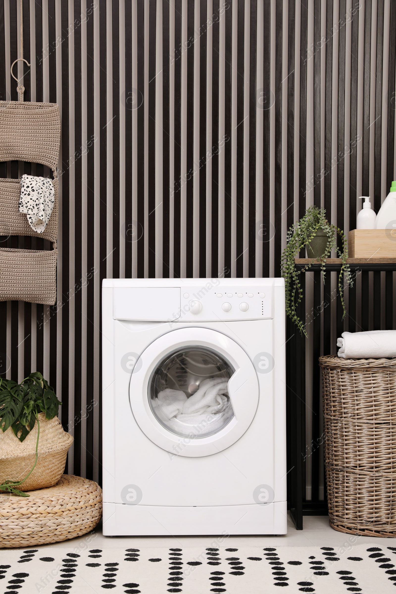 Photo of Stylish laundry room interior with washing machine