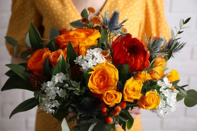 Woman with bouquet of beautiful orange roses, closeup