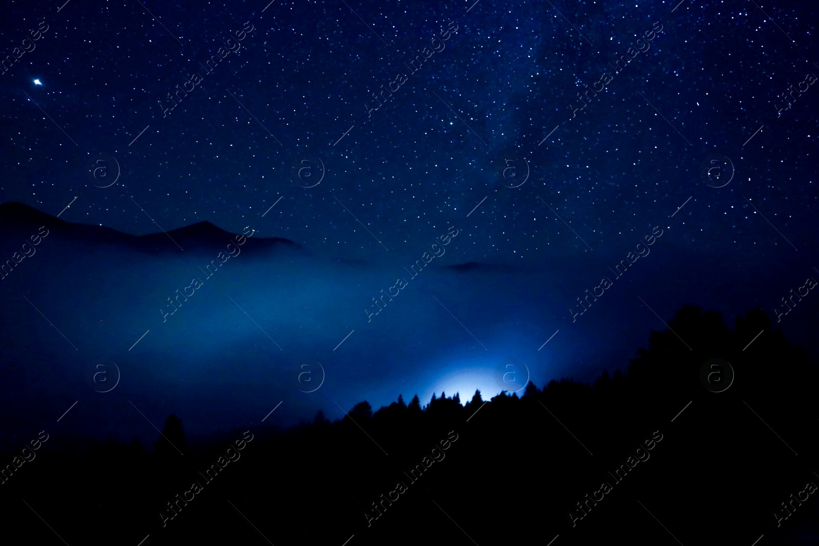 Image of Sky with twinkling stars over mountains at night