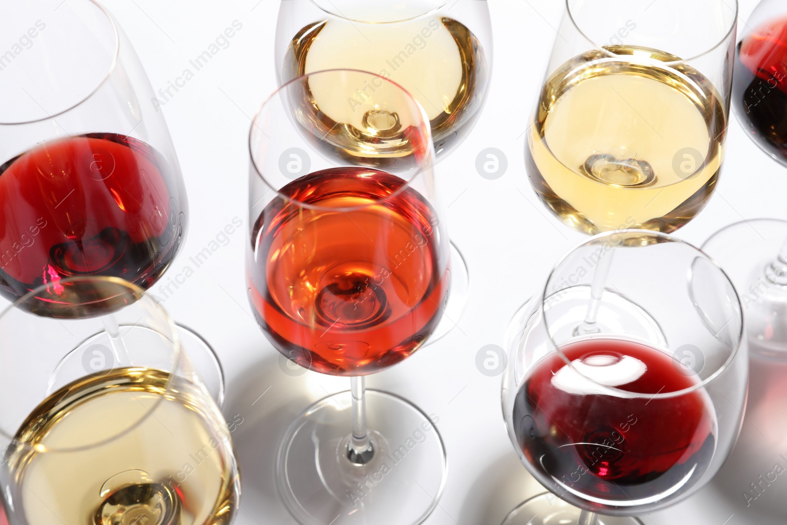 Photo of Different glasses with wine on white background