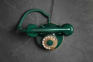 Vintage corded phone on black stone table, top view