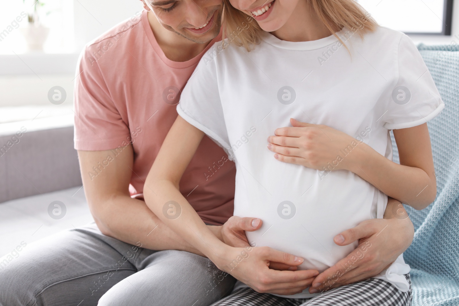 Photo of Young pregnant woman with her husband at home