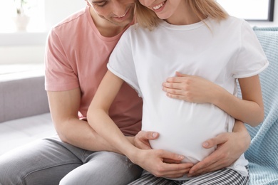 Young pregnant woman with her husband at home