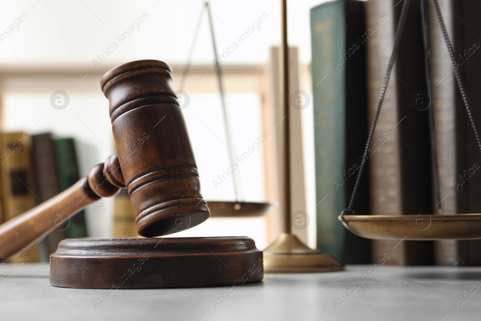 Photo of Wooden gavel, scales of justice and books on table, closeup. Law concept