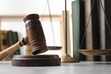 Wooden gavel, scales of justice and books on table, closeup. Law concept