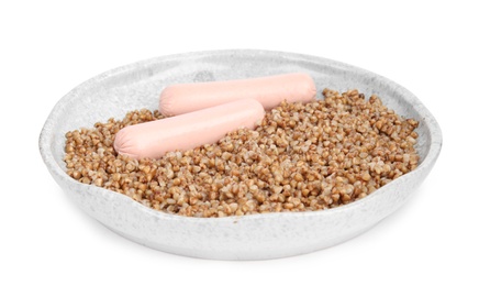 Delicious buckwheat porridge with sausages on white background