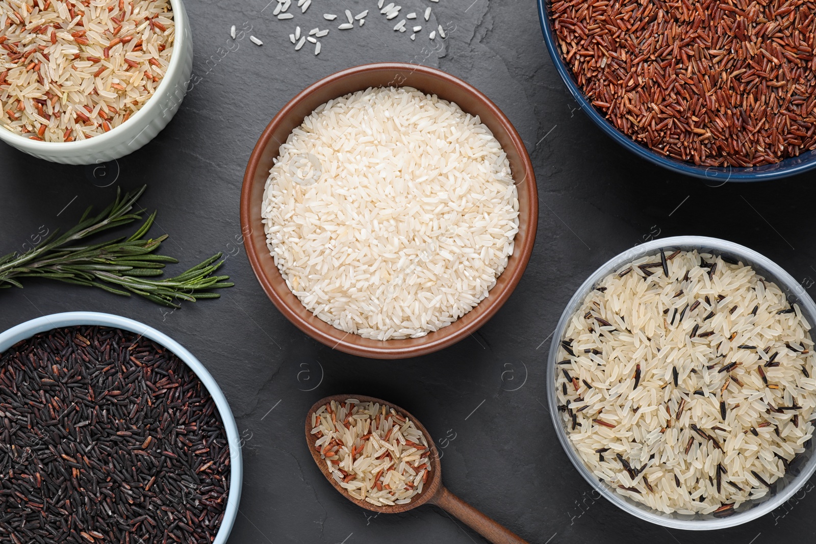 Photo of Flat lay composition with brown rice on black table