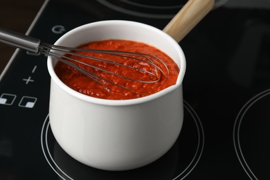 Photo of Cooking delicious tomato sauce in pan on stove, closeup