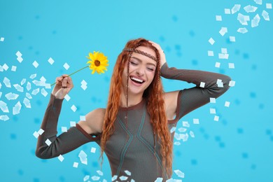 Happy woman and flying confetti on light blue background