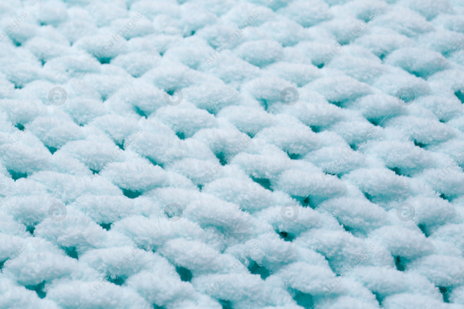 Photo of Soft light blue knitted fabric as background, closeup