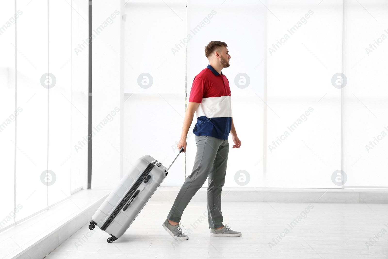 Photo of Young man with suitcase in airport