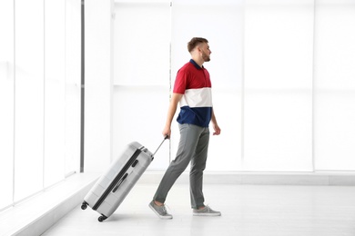 Photo of Young man with suitcase in airport