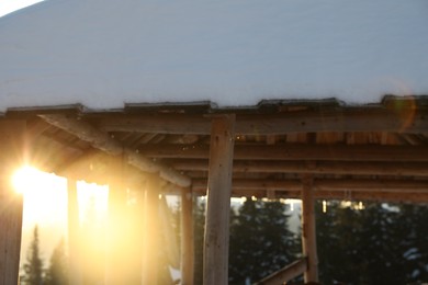 Photo of Wooden gazebo near snowy coniferous forest. Winter vacation