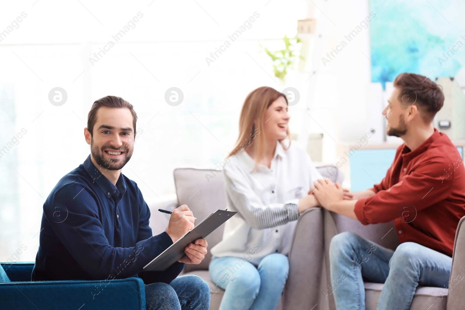 Photo of Professional psychologist and young couple in office