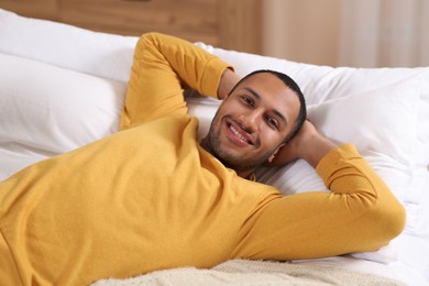 Photo of Portrait of smiling African American man on bed at home