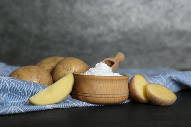 Photo of Starch and fresh raw potatoes on black table