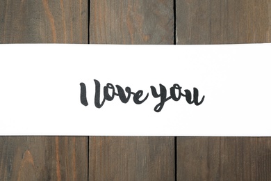 Card with text I Love You on wooden background, top view