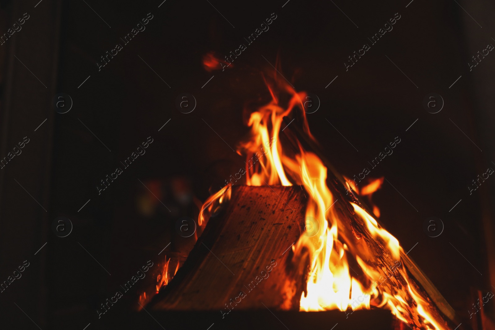 Photo of Fireplace with burning wood, closeup view. Winter vacation