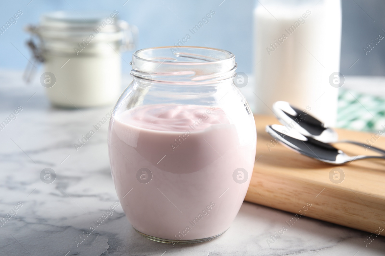 Photo of Glass jar of fresh yogurt on table