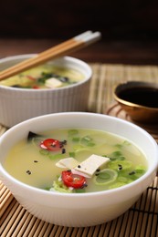 Photo of Bowls of delicious miso soup with tofu served on table, closeup