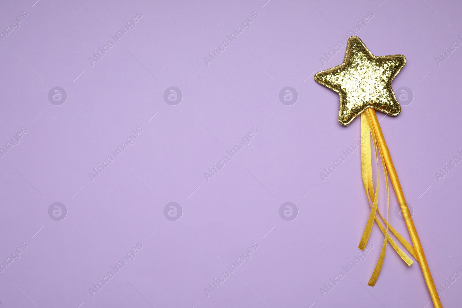 Photo of Beautiful golden magic wand on lilac background, top view. Space for text