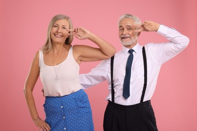 Photo of Senior couple dancing together on pink background