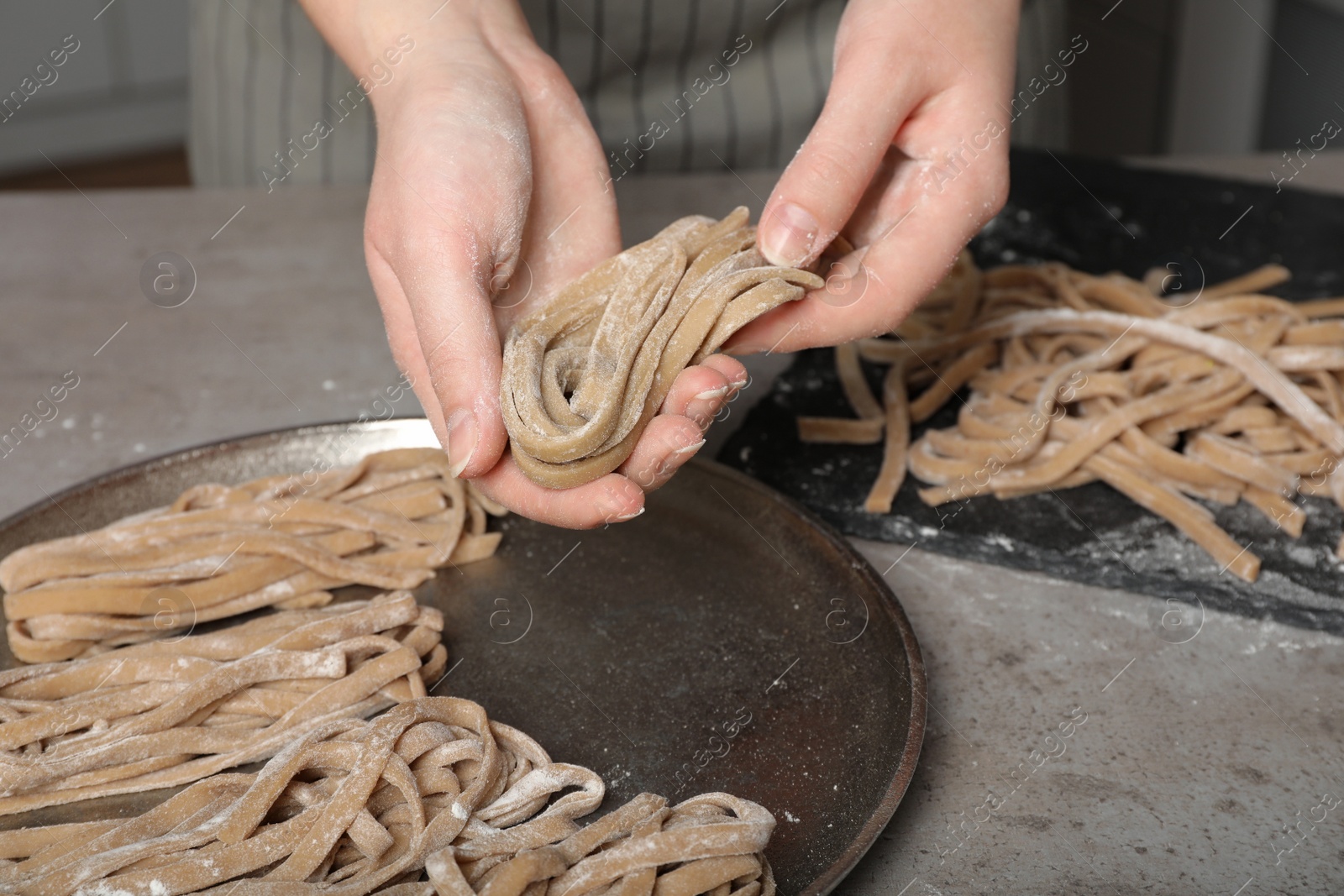 Photo of Woman making homemade soba at table, closeup