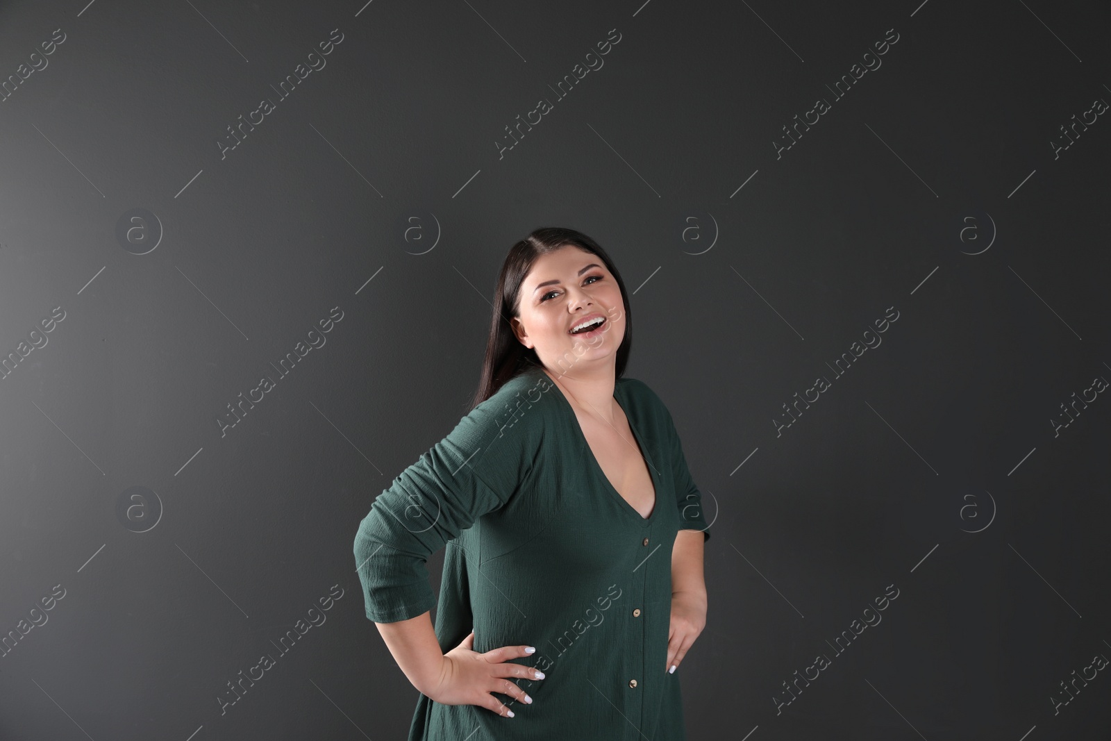 Photo of Beautiful overweight woman posing on black background. Plus size model
