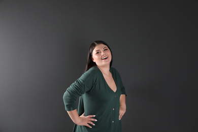 Photo of Beautiful overweight woman posing on black background. Plus size model