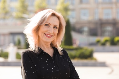 Portrait of happy mature woman on city street