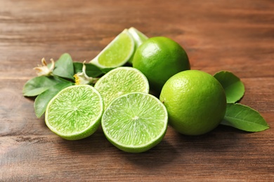 Photo of Fresh ripe limes on wooden table. Citrus fruit