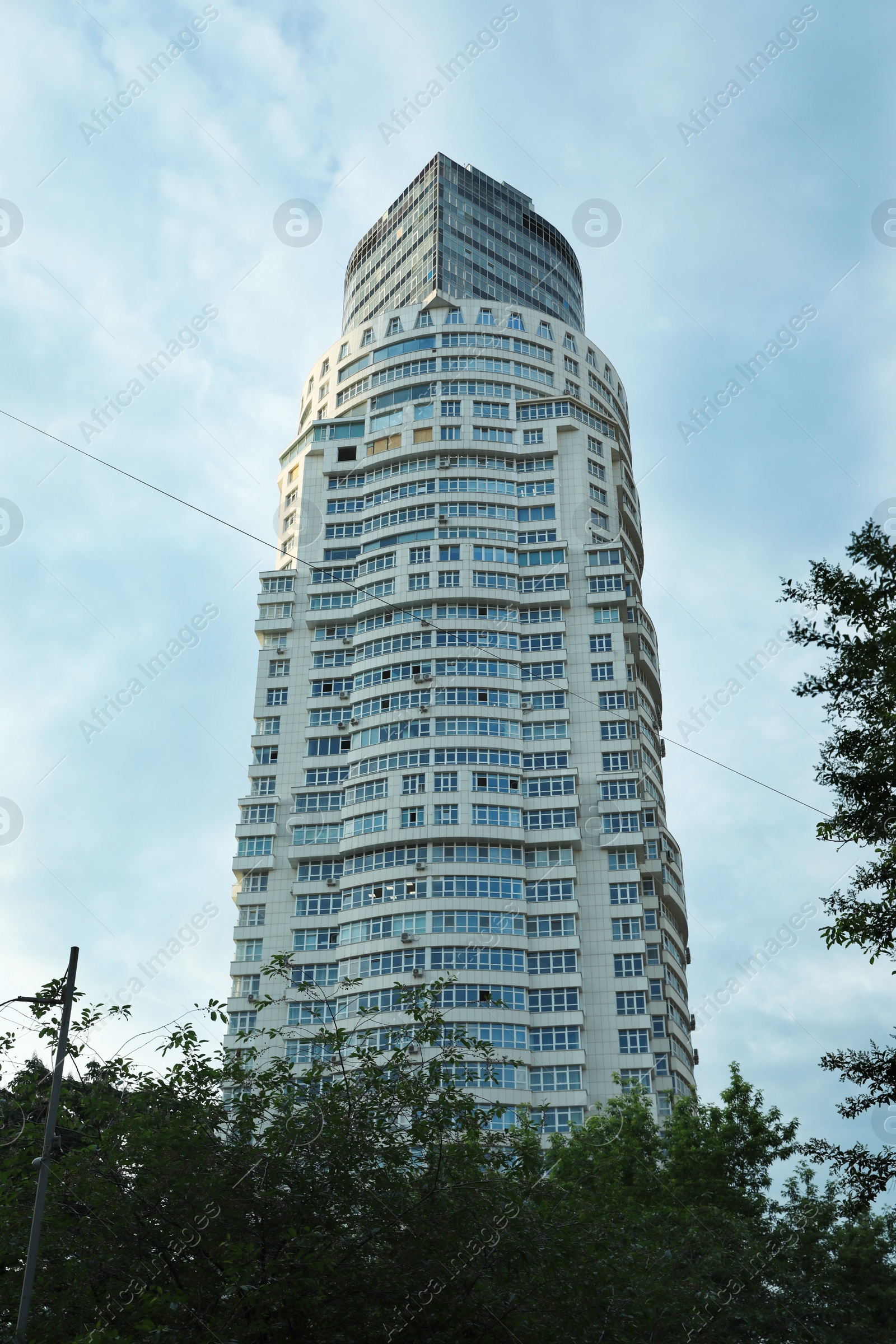 Photo of KYIV, UKRAINE - MAY 23, 2019: Modern dwelling building against sky with clouds