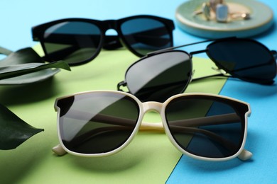 Photo of Different stylish sunglasses on color background, closeup