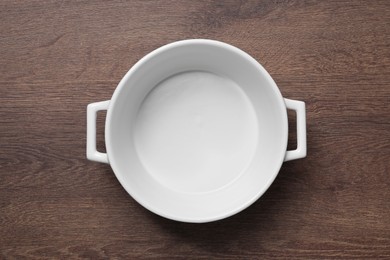 One white empty pot on wooden table, top view