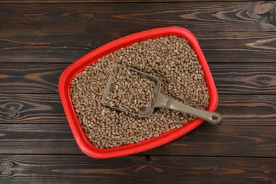 Photo of Cat litter tray with filler and scoop on wooden background, top view