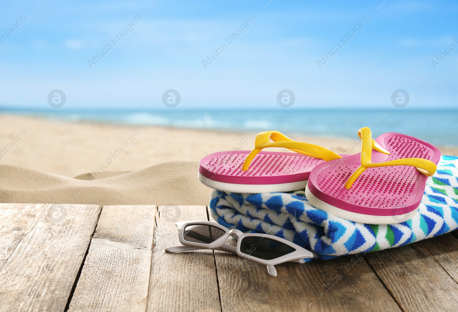 Image of Beach accessories on wooden surface near ocean, space for text