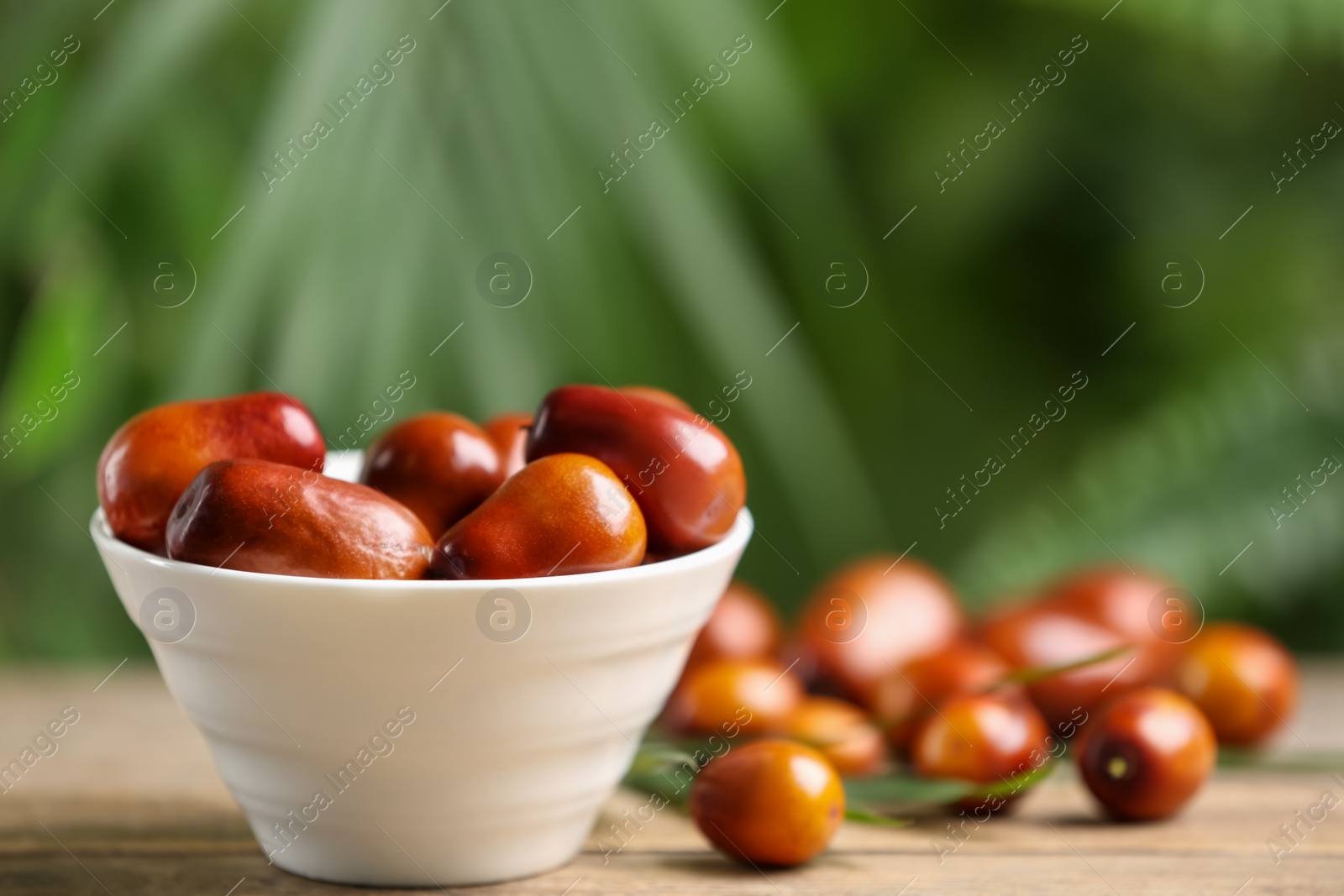 Photo of Fresh ripe oil palm fruits on wooden table, closeup. Space for text