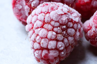Photo of Frozen ripe raspberries on light table, closeup