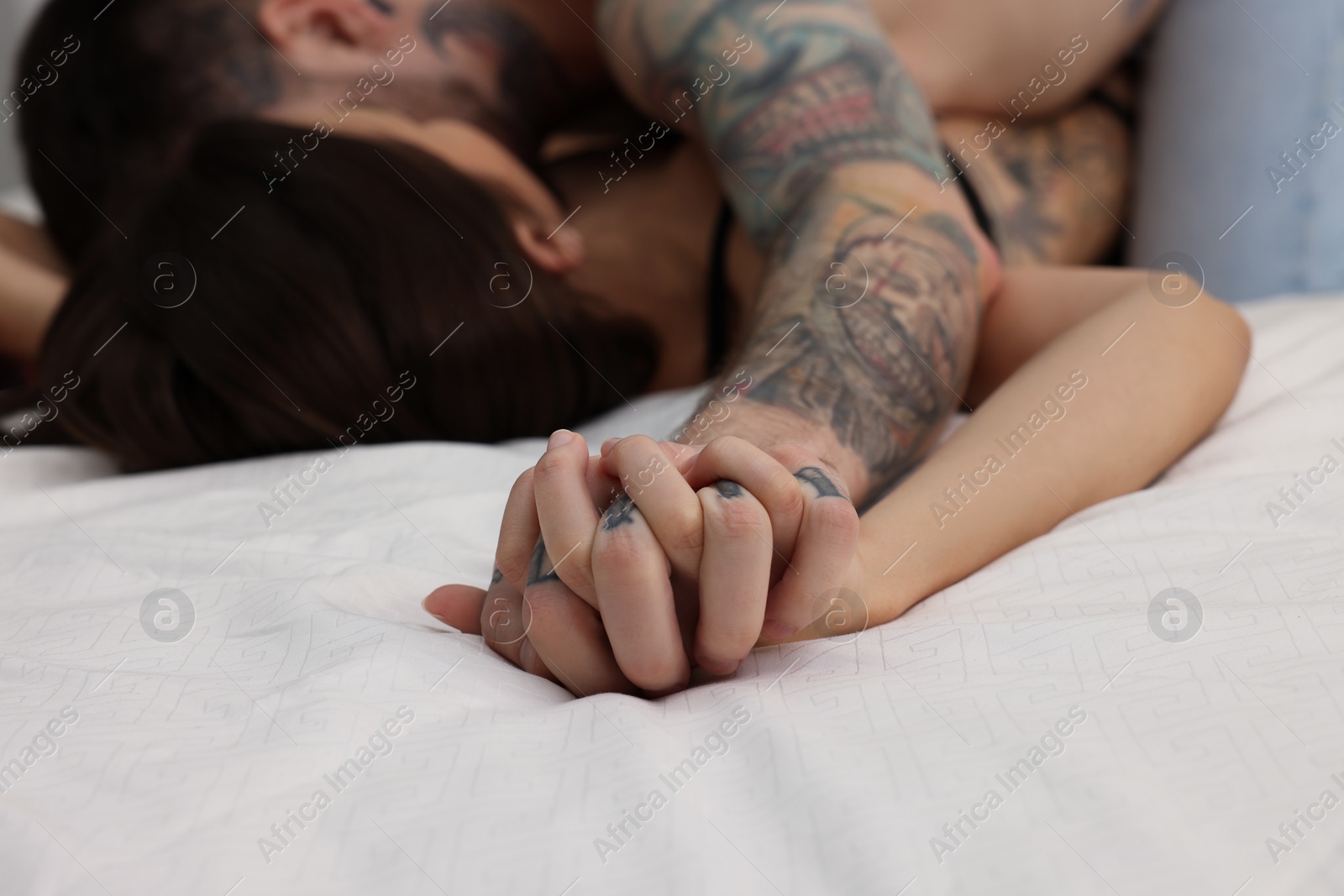 Photo of Passionate couple having sex on bed, closeup