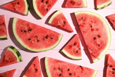 Photo of Slices of ripe watermelon on pink wooden table, flat lay