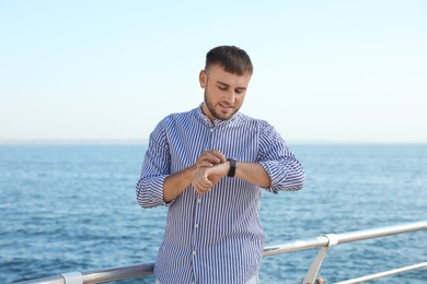 Photo of Portrait of handsome young man on sea pier